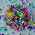 Retro Pick-Me Pad – overhead view of colorful sensory pad with pony beads, smiley faces, game controllers, boombox and cassette tape charms