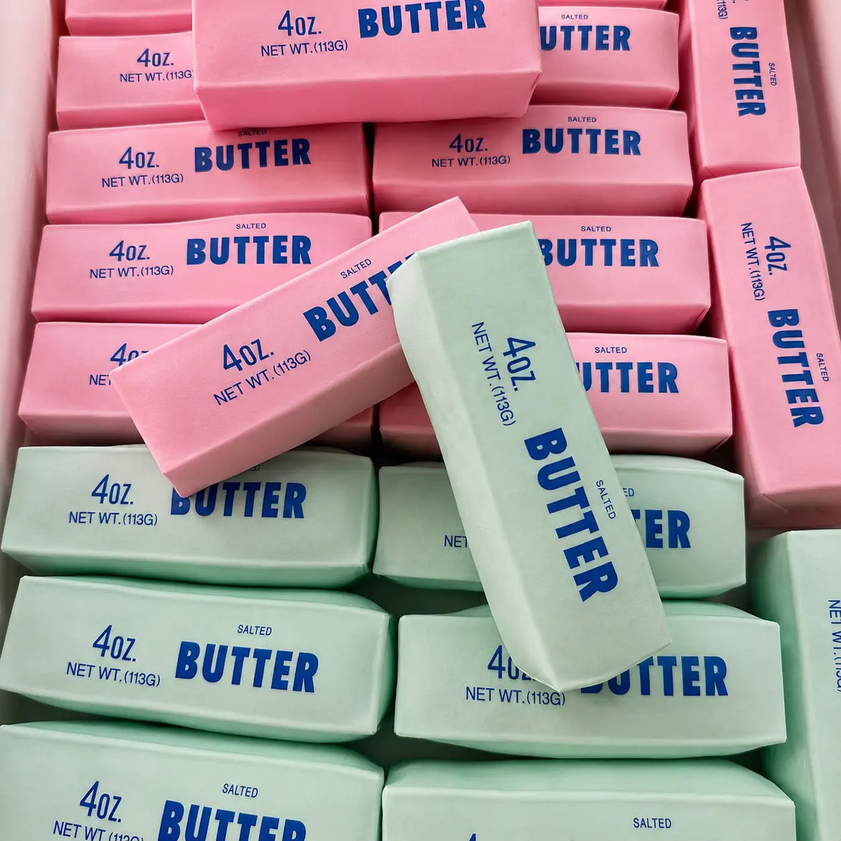 Pink and mint-green butter-shaped squishy toys labeled BUTTER